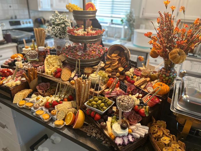 A vibrant and abundant charcuterie spread with various cheeses, fruits, and snacks.