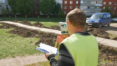 Man using level to grade soil