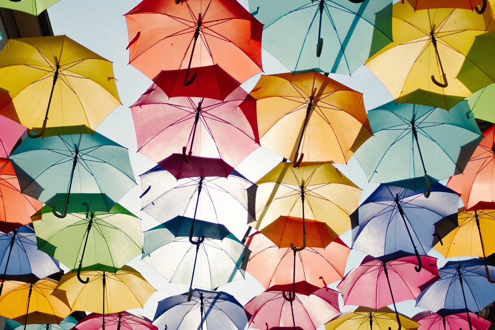 Parapluies colorés suspendus dans le ciel.