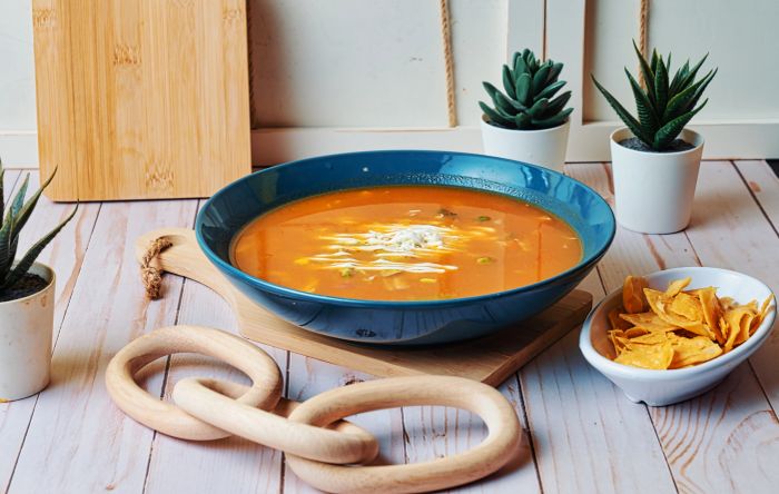 A bowl of Sopa Azteca with cream, avocado and tortilla strips.