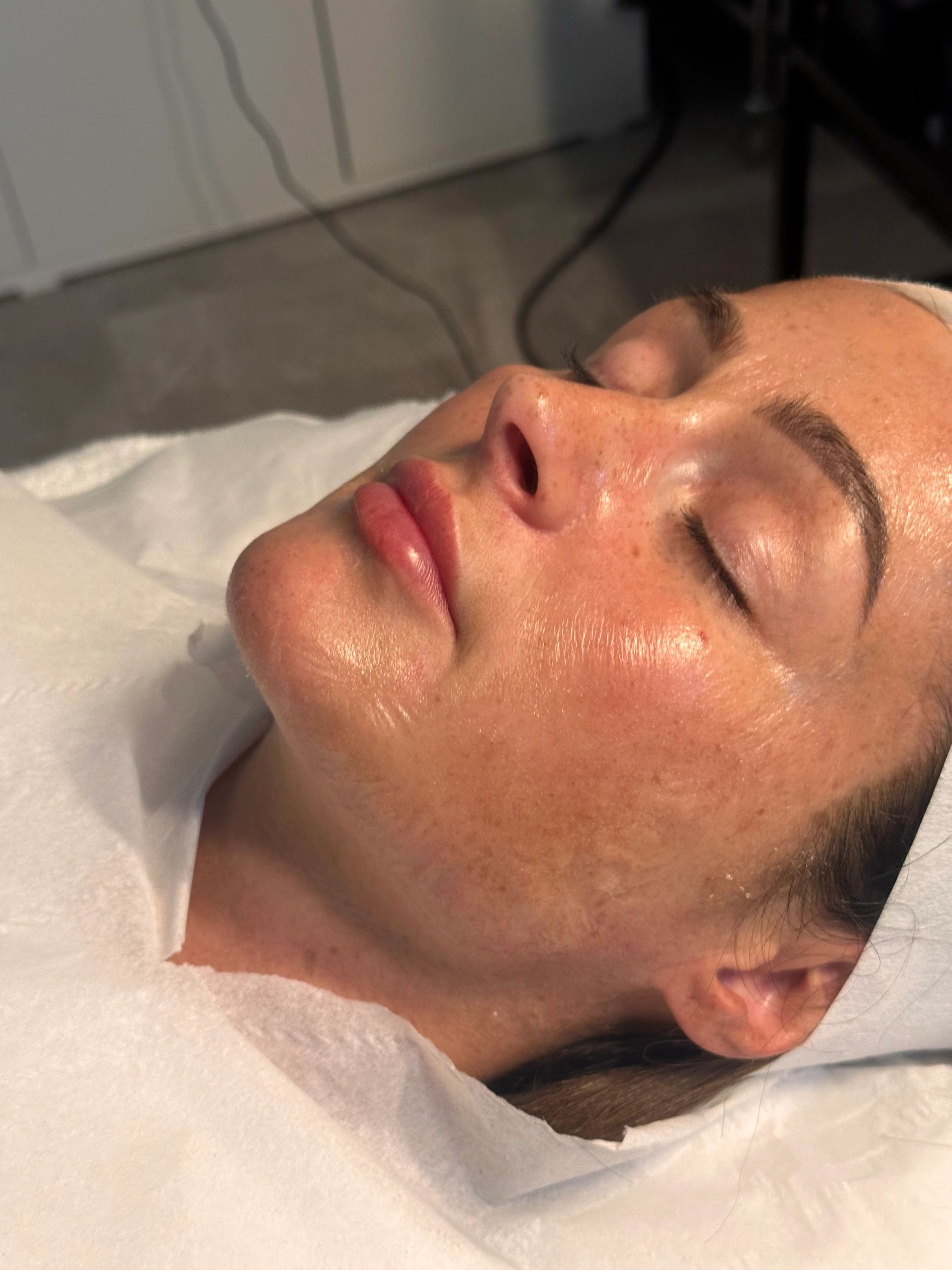 Close-up of a woman with glowing skin resting peacefully.