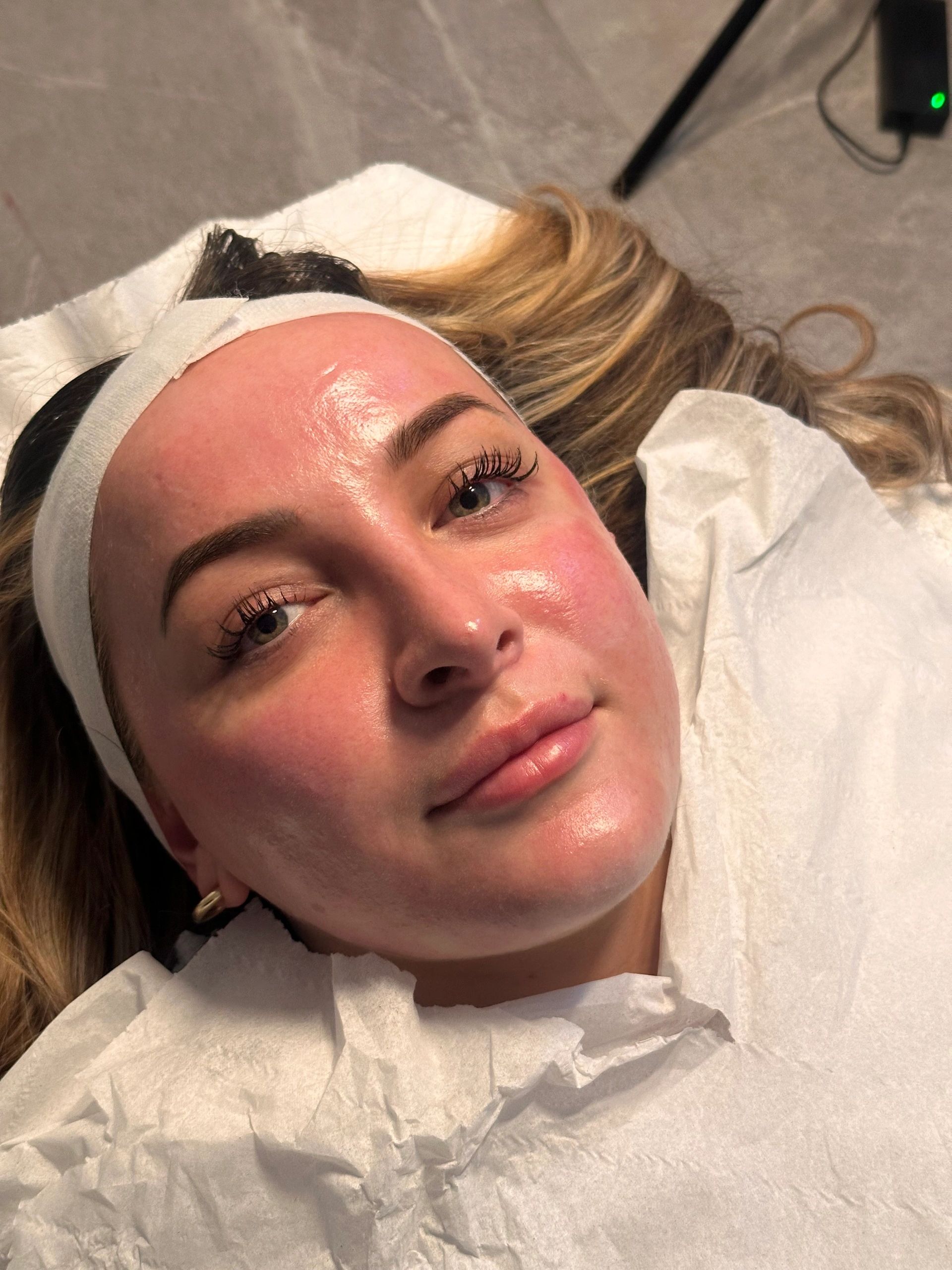 Close-up of a woman with glowing skin during a facial treatment.