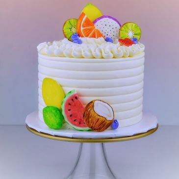 White cake decorated with colorful fruit-shaped toppings.