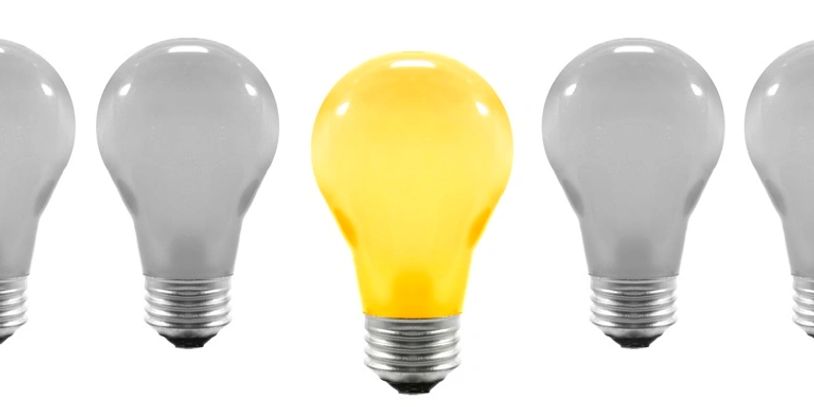 Row of light bulbs with only one, the center bulb, glowing.