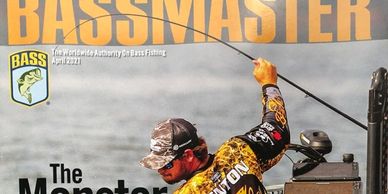 Angler reeling in a bass on the cover of Bassmaster magazine.