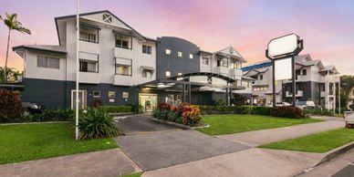 Modern hotel exterior at sunset with well-maintained landscaping.