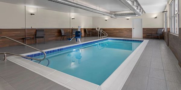 Indoor swimming pool with seating and accessibility features.