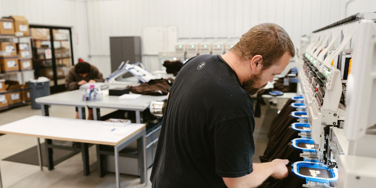 Complete Team Outfitter employees working in the embroidery department