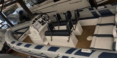 A docked inflatable boat with blue and white seating.