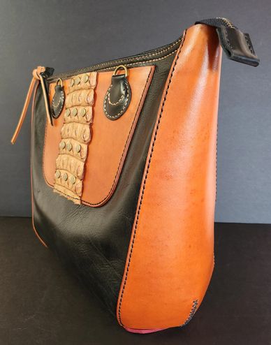 Stylish black and brown leather handbag with textured detail on front.