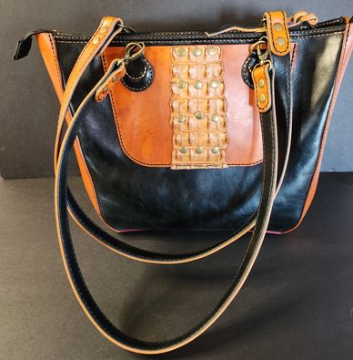 Black and brown leather handbag with decorative studs and long straps.