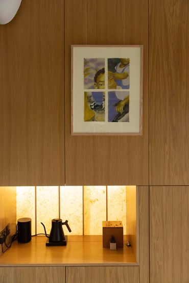 Modern wooden kitchen with minimalist decor and framed abstract art.