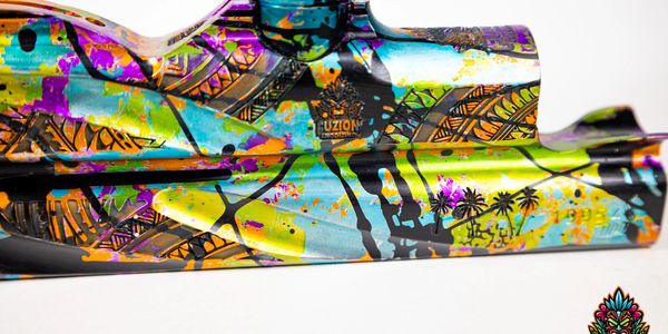 Colorful anodized metal part with tropical and geometric designs.