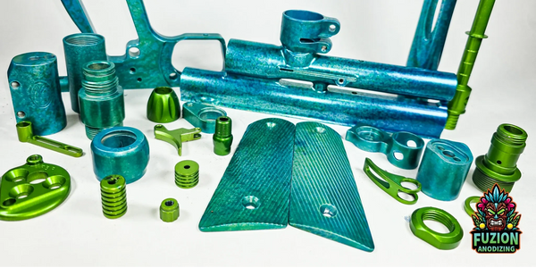 Various anodized metal parts in blue and green on a white background.