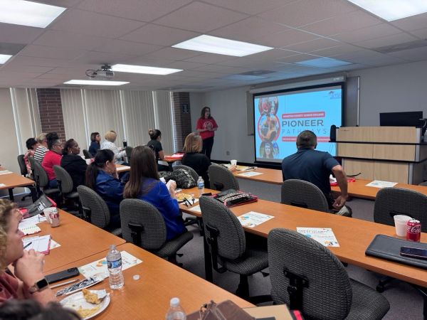 People attend a presentation titled 'Pioneer Pathways' in a classroom setting.