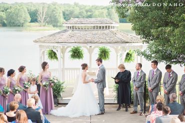 Bride and groom exchanging vows at an outdoor gazebo wedding ceremony.