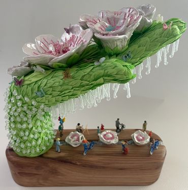 Mannequin Hand embellished with ceramic flowers, ribbon, miniature people. miniature butterfiies and
