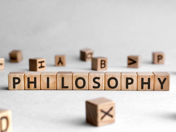 Wooden blocks spell out the word 'PHILOSOPHY' on a light surface.
