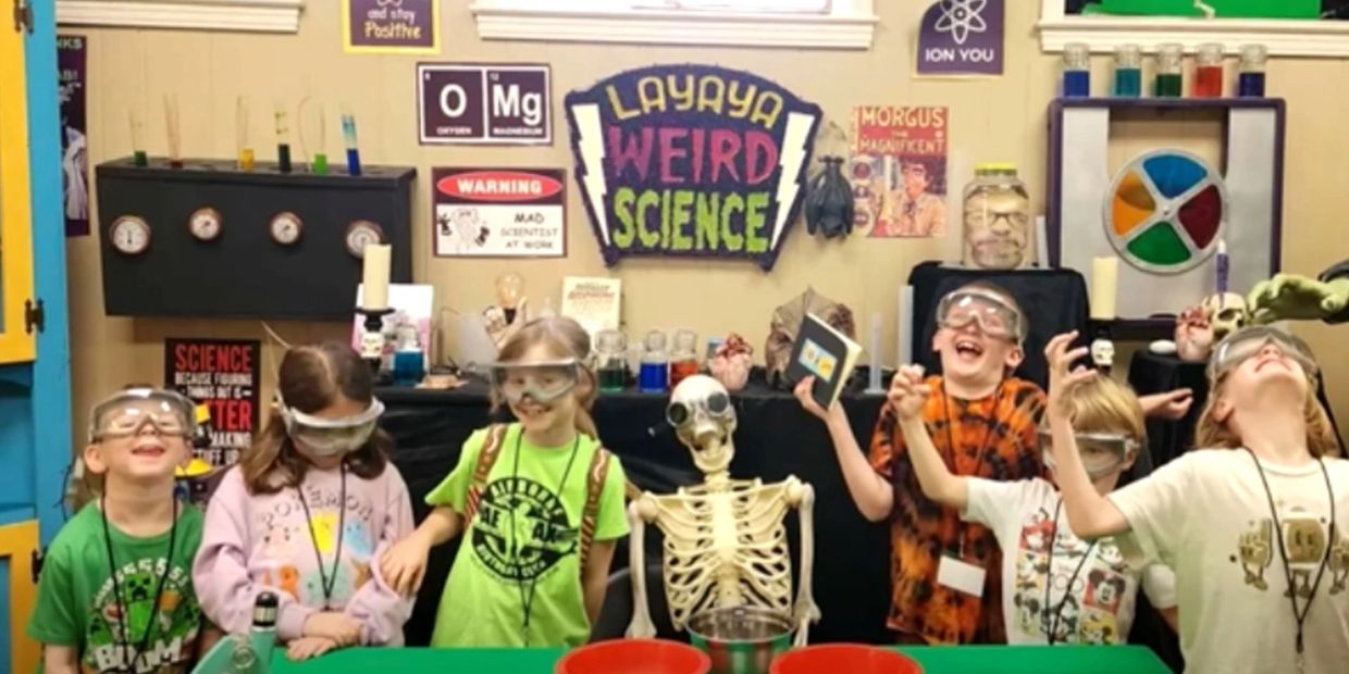 Kids having fun in a colorful science classroom with a skeleton.