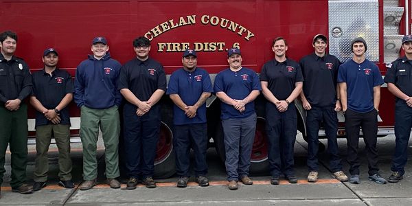 New firefighter recruits in front of fire engine