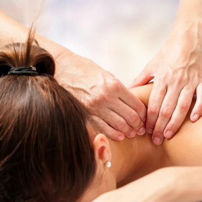 A person receiving a shoulder massage from another individual.