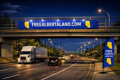 A highway at night with a banner and flag promoting Free Alberta Land.