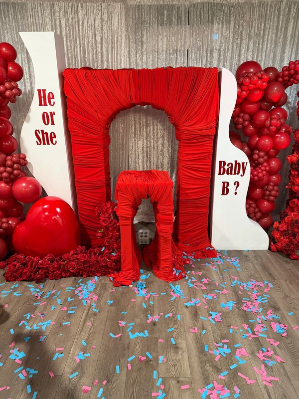 Custom red gender reveal event backdrop and balloon installation in Baltimore.
