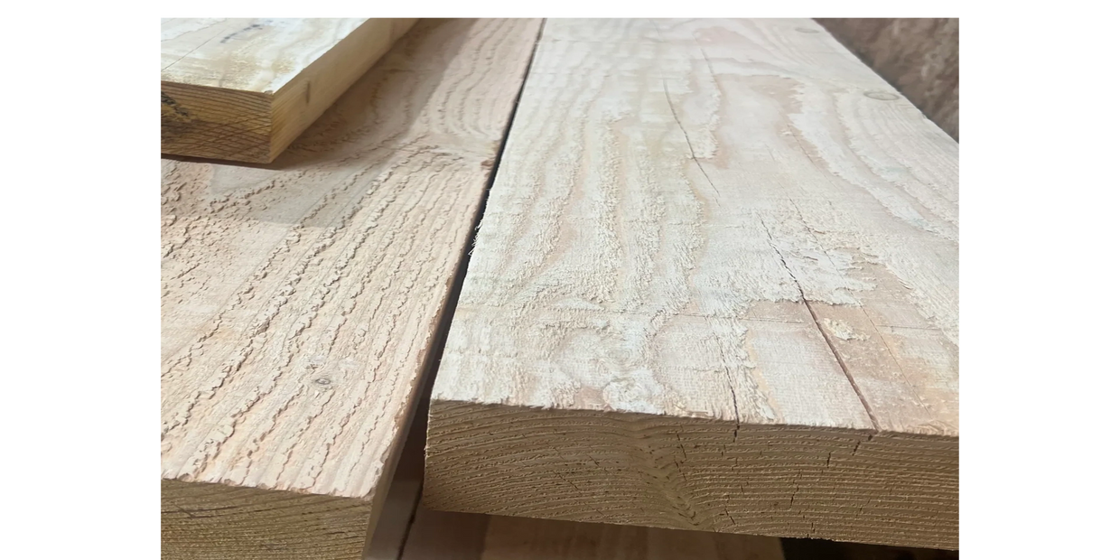 Close-up of raw wooden planks stacked together.