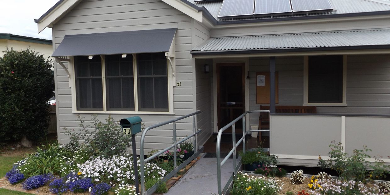 Small house with ramp, garden, and solar panels.