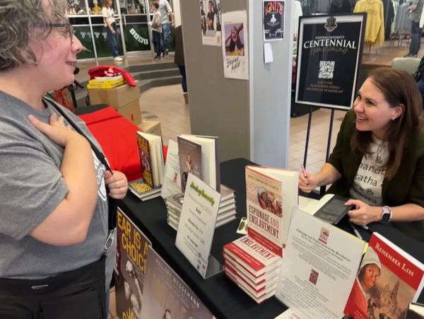 Author at book signing, speaking with smiling woman