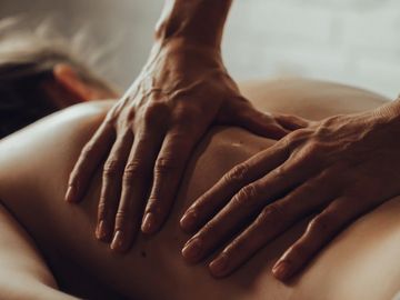 Hands giving a relaxing back massage.