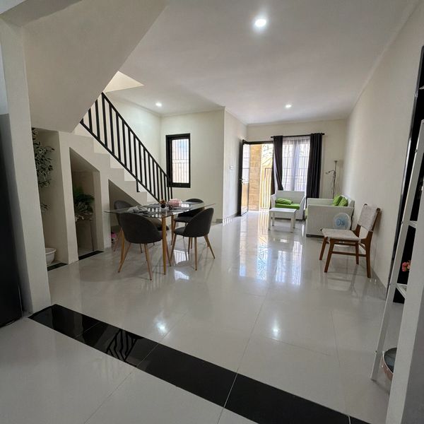 Modern open living and dining area with white tile flooring.