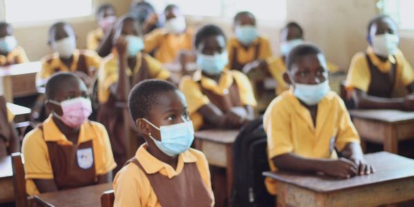 School children wearing masks in classroom.
