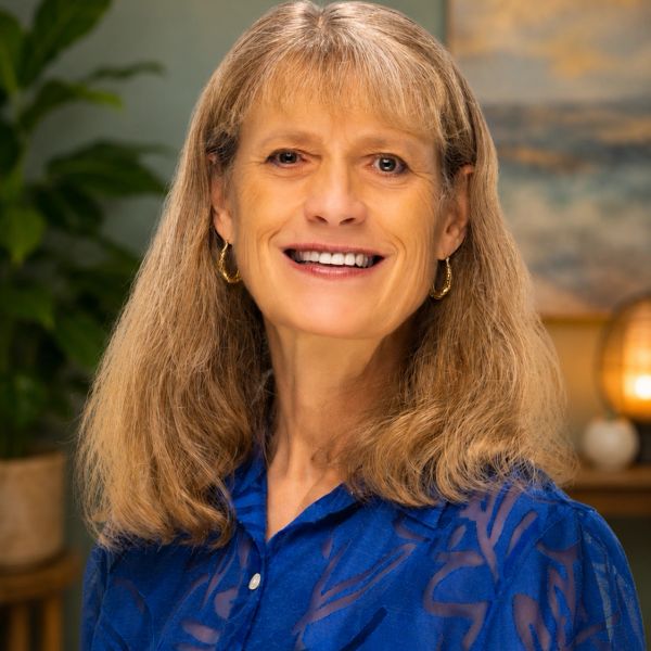 Smiling woman with blonde hair in a blue blouse.