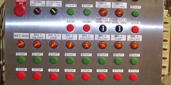 Control panel with various labeled buttons for operating gates, bins, and tanks.