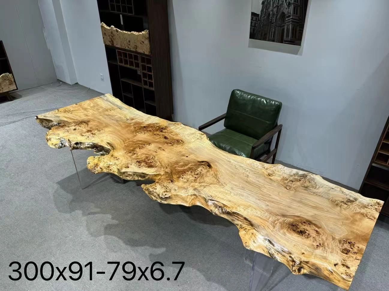 Live edge wooden table with natural grain and a green leather chair.