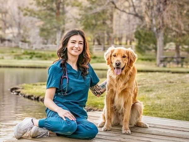 Veterinarian with golden retriever by a lake.