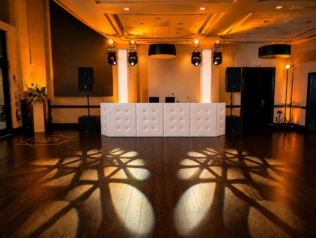 White luxury DJ booth with professional sound and event lighting at a wedding reception.