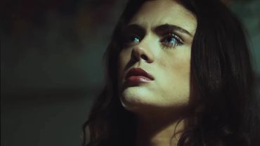 A woman looking up with a serious expression.