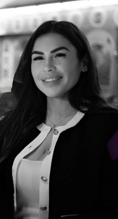Smiling woman with long dark hair in black and white portrait.