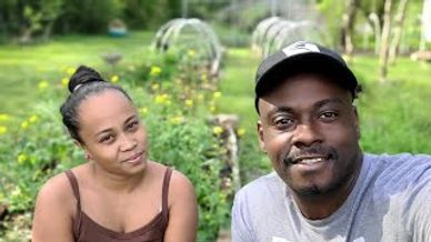 A smiling couple taking a selfie outdoors in a green garden.