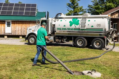 Man vacuuming septic tank with truck.