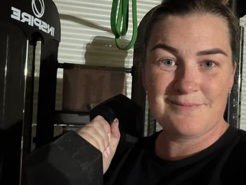 Woman holding a dumbbell in a gym.