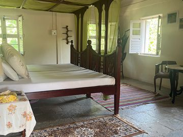 Vintage bedroom with a wooden bed and open window.