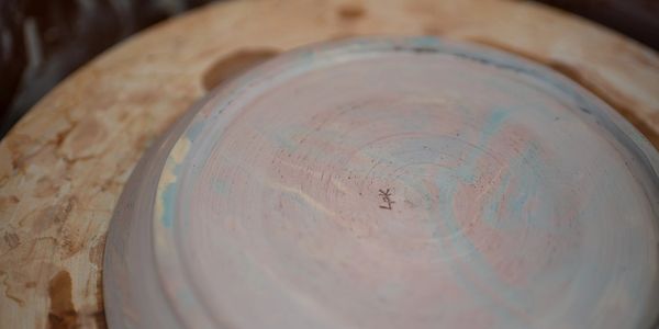 Close-up of a pottery piece on a wooden wheel.