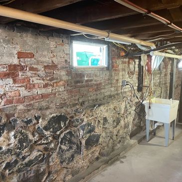 Stone foundation in need of repairs and restoration. Stone foundation crumbling walls.