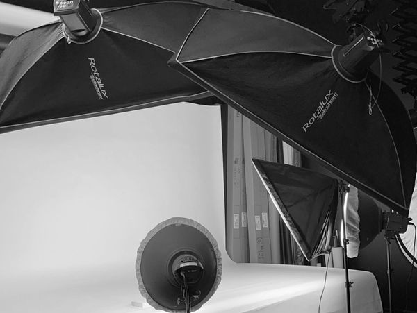 Photography studio lighting setup with softboxes and reflectors.