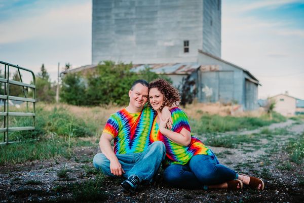 two couple sitting on ground holding each other