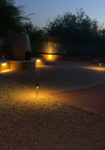 Outdoor patio area illuminated by soft yellow lights at night.