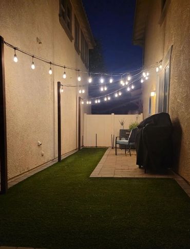 Cozy backyard patio with string lights at night.